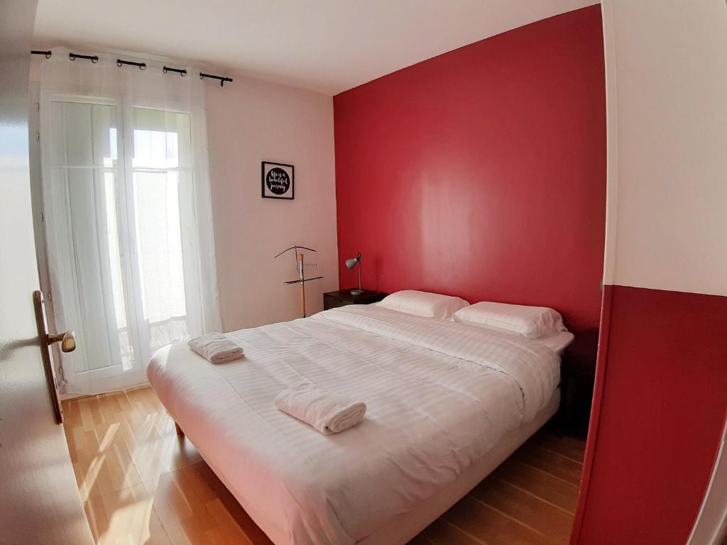 Schlafzimmer mit einem großen Bett mit roten Wänden in der Unterkunft Disney, very nice 2 bedrooms family apartment, wifi, NETFLIX 8 pers in Chessy