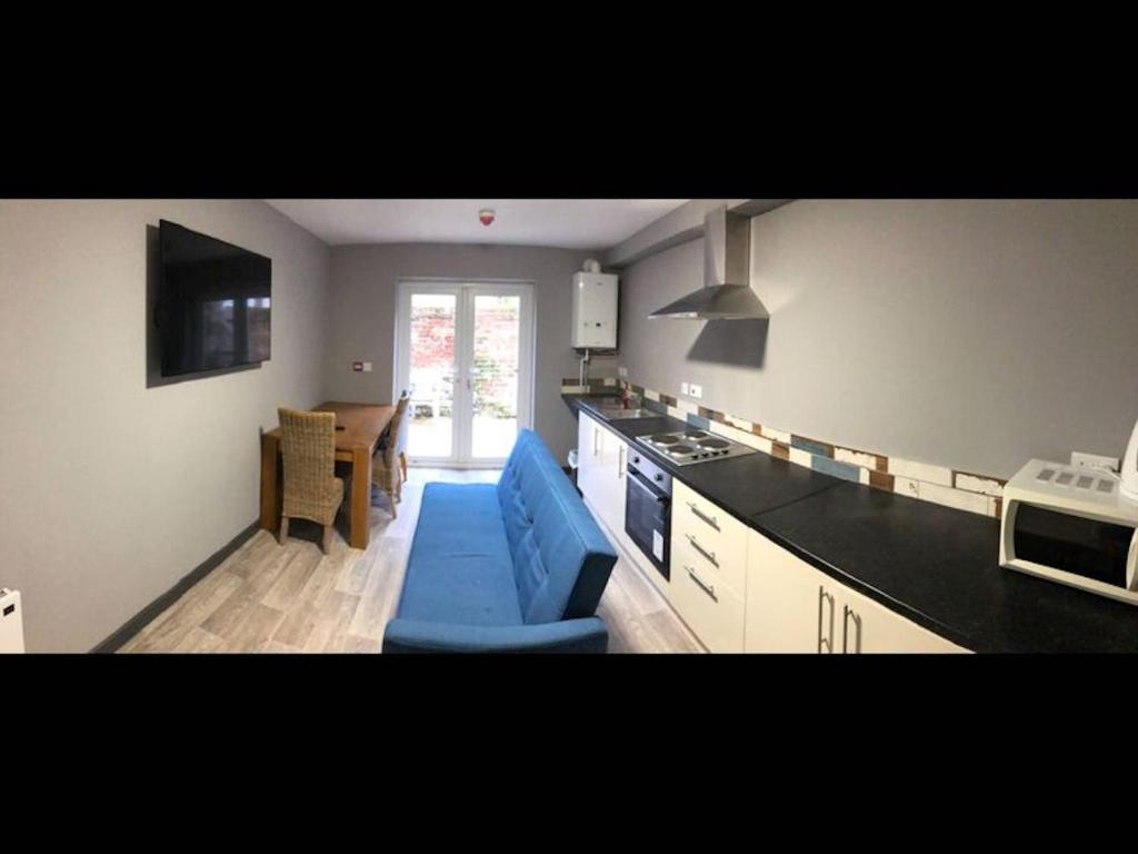 a kitchen with a blue couch in a room at Room in House - Private En-suite Room In Town, Close To Hospital in Kings Lynn