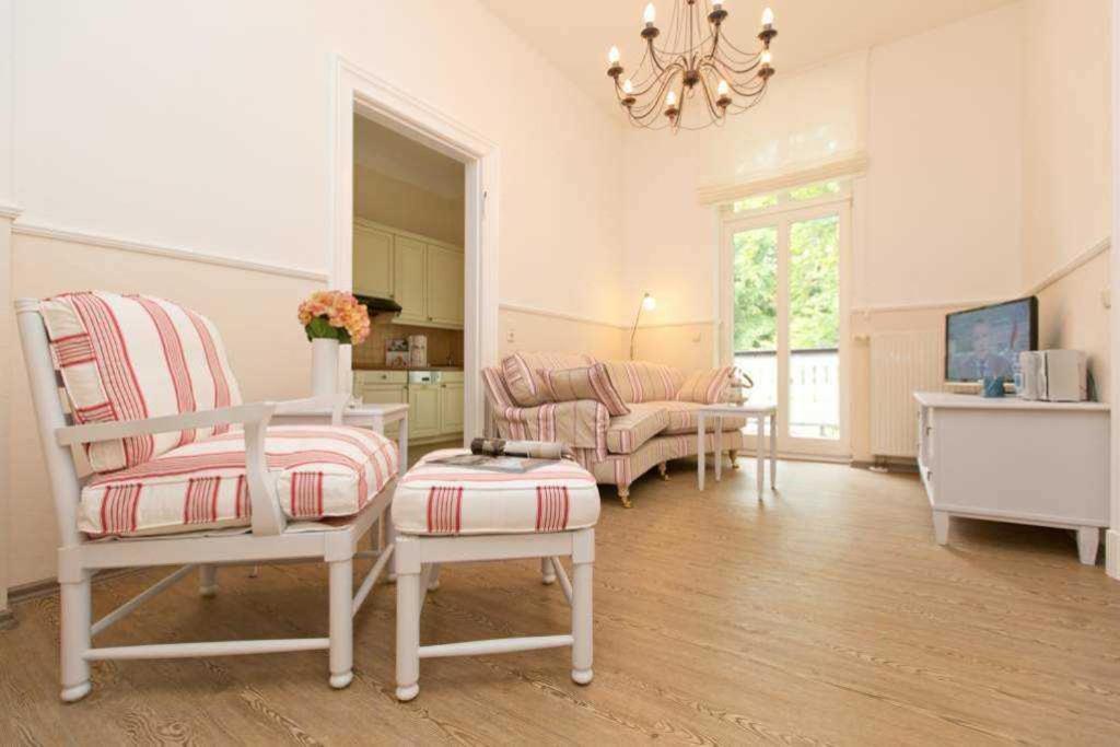 uma sala de estar com duas cadeiras e uma mesa em Villa Amelia App 05 em Heringsdorf