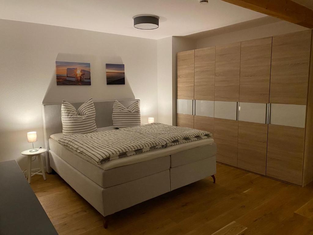 a bedroom with a large bed and a large cabinet at Landhaus "Alte Welt" Nordseeküste in Osteel