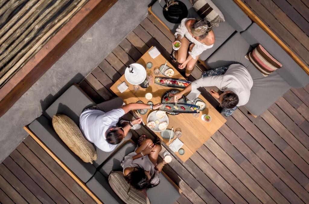 a group of people sitting around a wooden table at OKU Ibiza in San Antonio