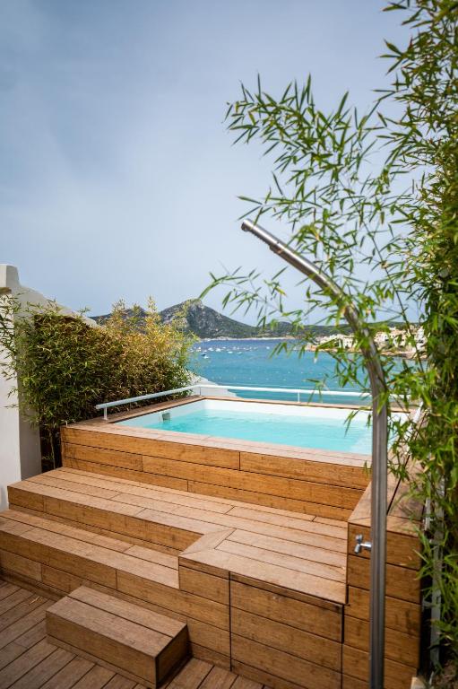 安德拉特斯JUST EXPERIENCE MALLORCA的房子里有一个游泳池，有木质台阶，面向大海