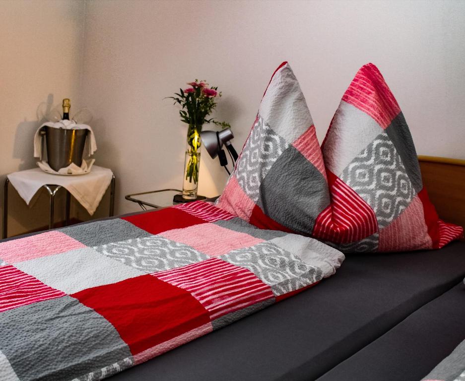 1 dormitorio con 1 cama con almohadas rojas y grises en Haus Marianne, en Franzhausen