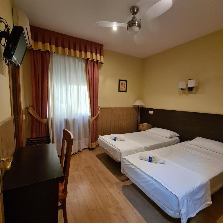 a hotel room with two beds and a television at Hostal Oporto in Madrid