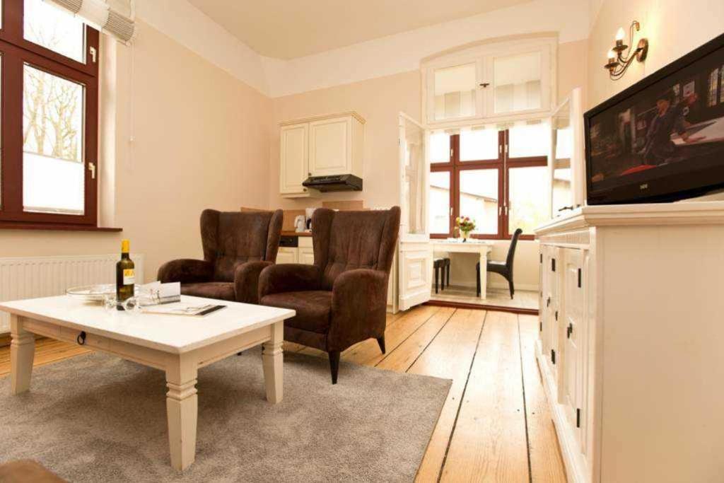 ein Wohnzimmer mit einem Tisch und 2 Stühlen in der Unterkunft Villa Arcadia, App. 05 in Heringsdorf