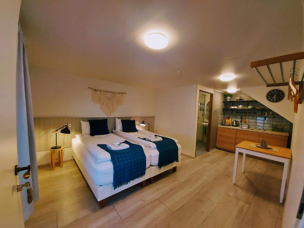 Un dormitorio con una cama y una mesa. en Grásteinn Guesthouse, en Þórshöfn