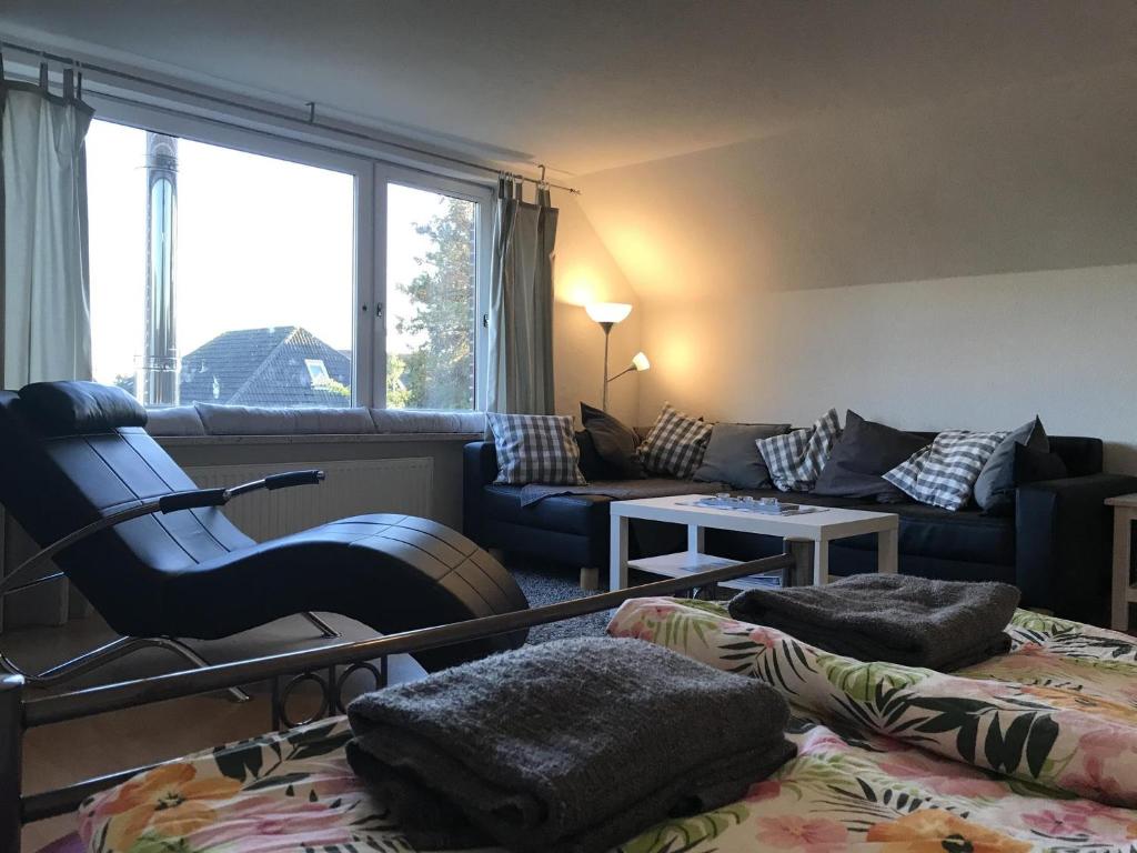 een woonkamer met een bank en een stoel bij Ferienwohnung Gödde in Butjadingen