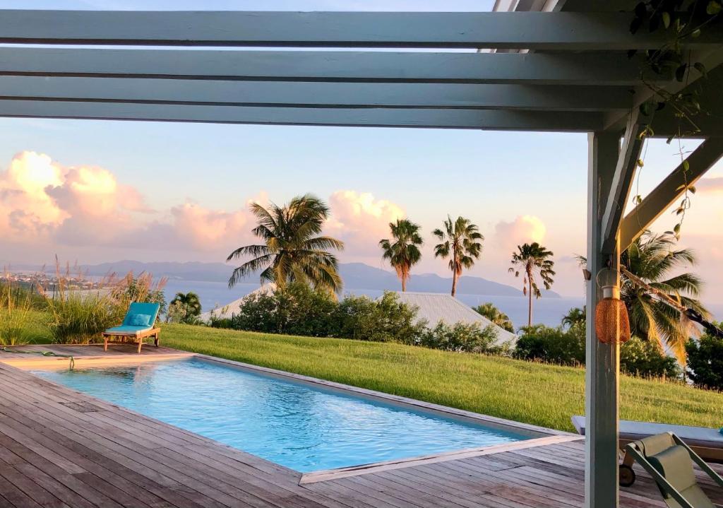 a swimming pool with a view of the ocean from a house at VILLA AQUA in Case-Pilote