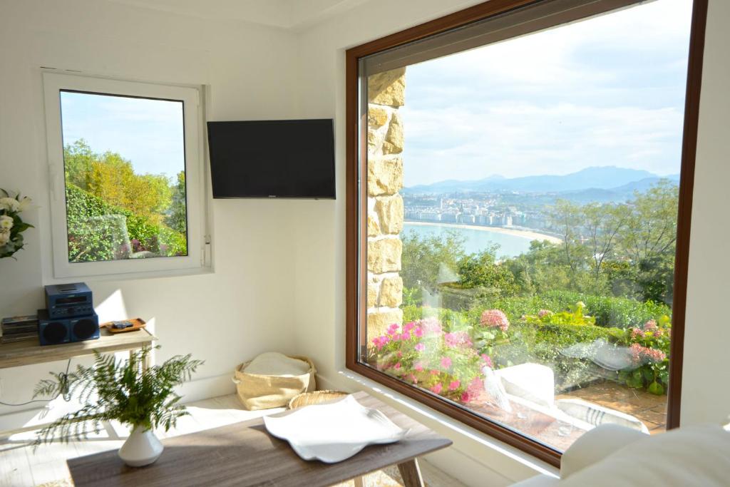 a room with a table and a large window with a view at Go Donosti Romanticismo in San Sebastián