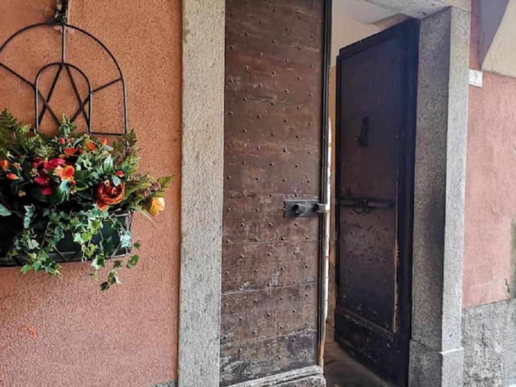una puerta con una cesta de flores en el lateral de un edificio en POETI&MISùLTIN. POESIA E VACANZA SUL LAGO en Menaggio