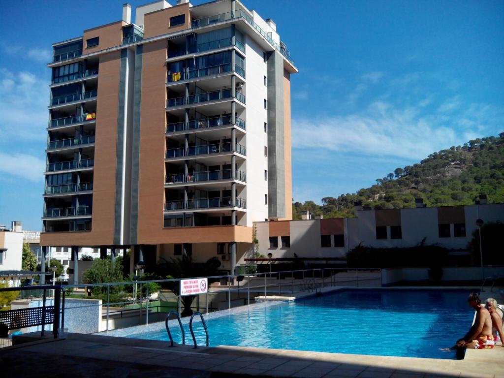 a hotel with a swimming pool in front of a building at Apartamentos Tamarindo Cala de Finestrat in Cala de Finestrat