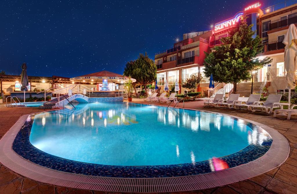 a large swimming pool in a hotel at night at Hotel Sunny in Sozopol