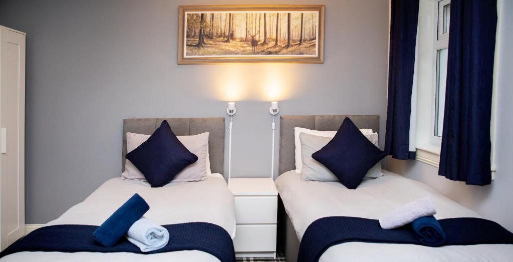 - deux lits assis l'un à côté de l'autre dans une pièce dans l'établissement St Andrews Guest House, à Irvine