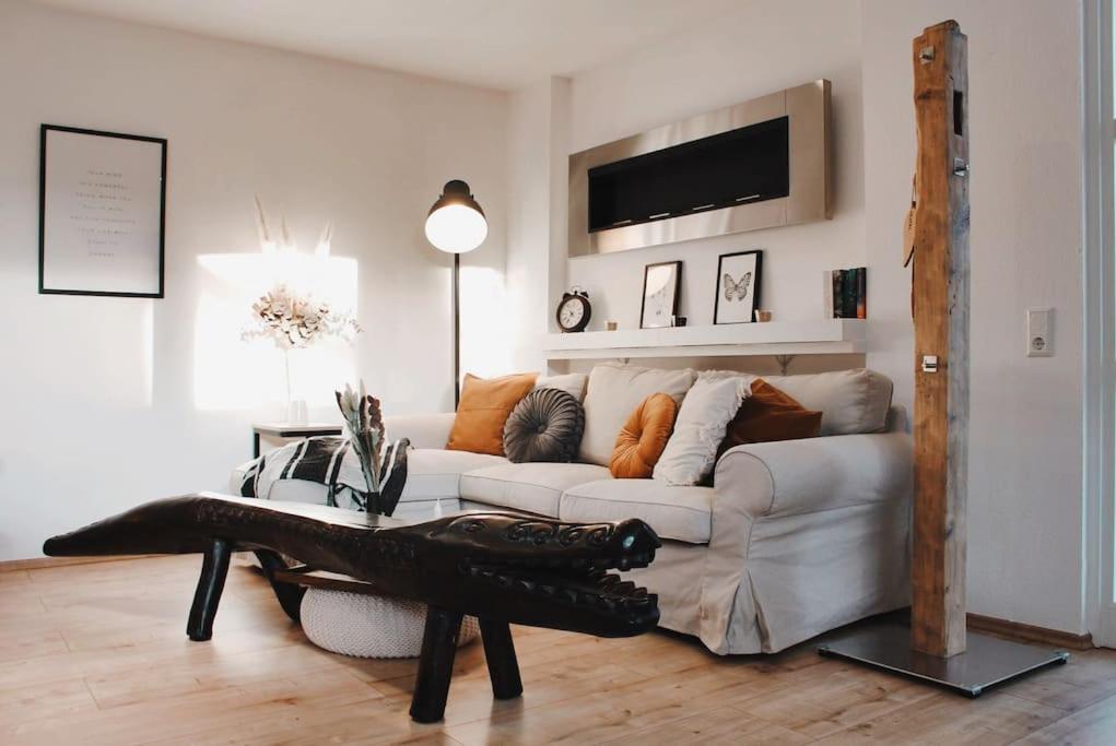 uma sala de estar com um sofá branco e uma mesa em Smart-Apartment BlickWinkel Schwarzwald em Gaggenau