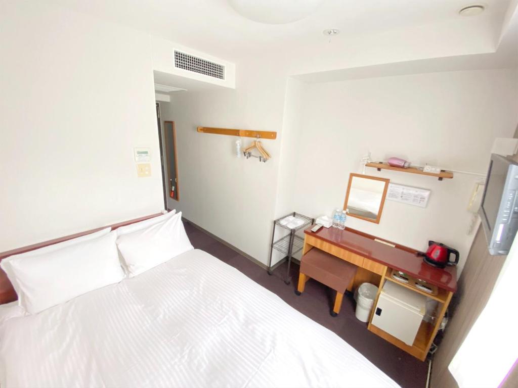 東京にあるWEB Hotel Tokyo Asakusabashi / Vacation STAY 8770のベッドとデスクが備わる小さな客室です。