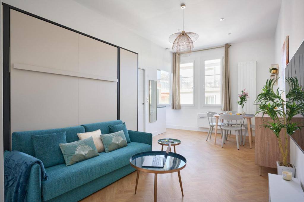 un salon avec un canapé bleu et une table dans l'établissement Sunlight Properties - Daffia - Beautifully renovated studio, city pad in Central Nice, à Nice