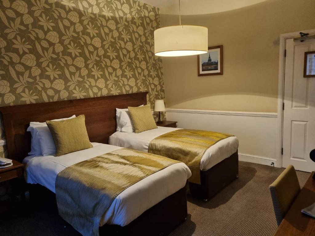 Postel nebo postele na pokoji v ubytování Saracens Head Hotel by Greene King Inns