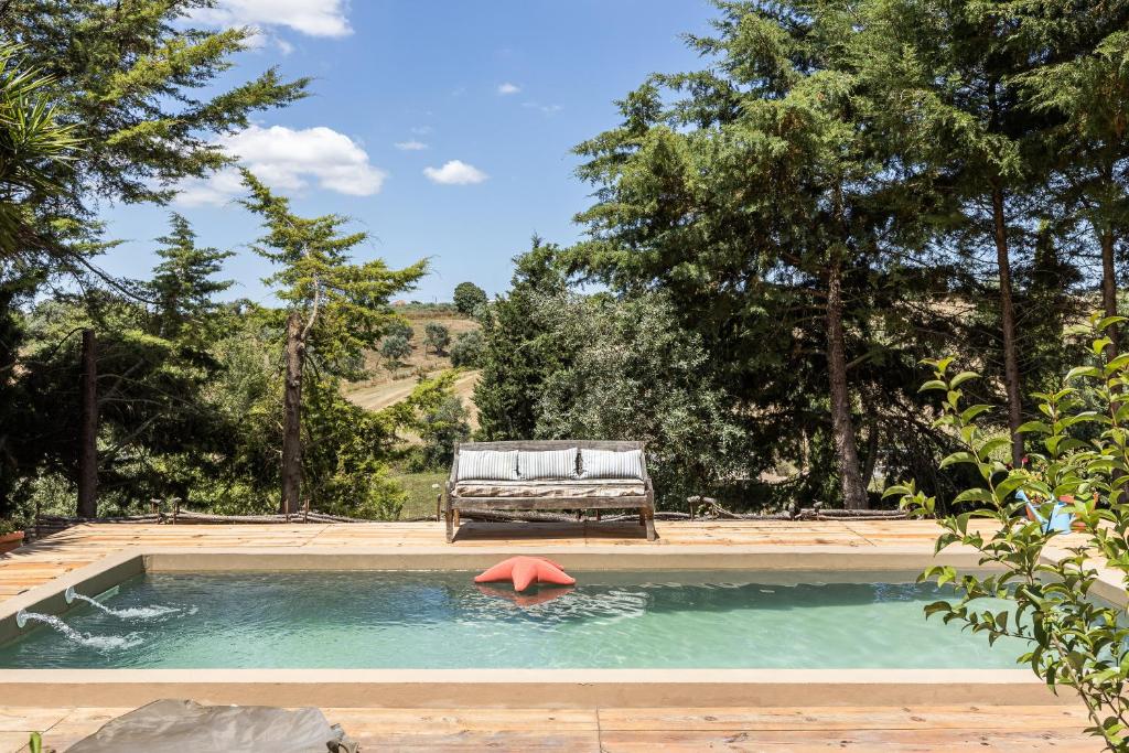 una piscina con un banco y una silla en un patio en Dominio Vale Flores, en Advagar