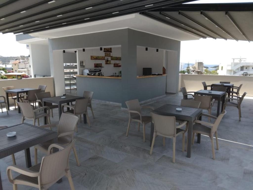 a restaurant with tables and chairs on a roof at Hotel Ksamili in Ksamil