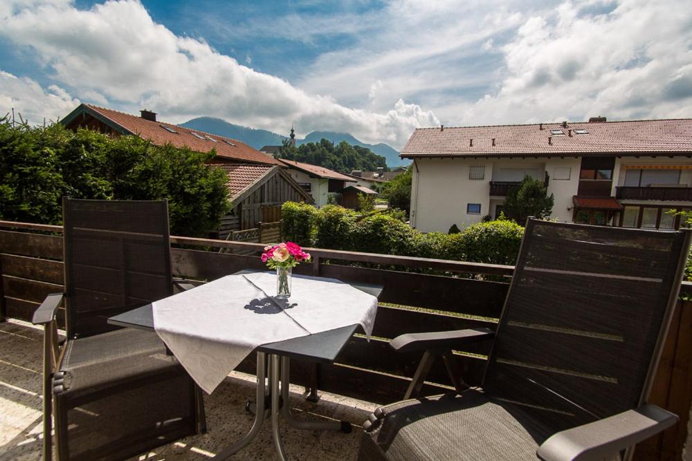 a table with a vase of flowers on a balcony at Ferienwohnung Plenk inkl. Chiemgaukarte in Ruhpolding