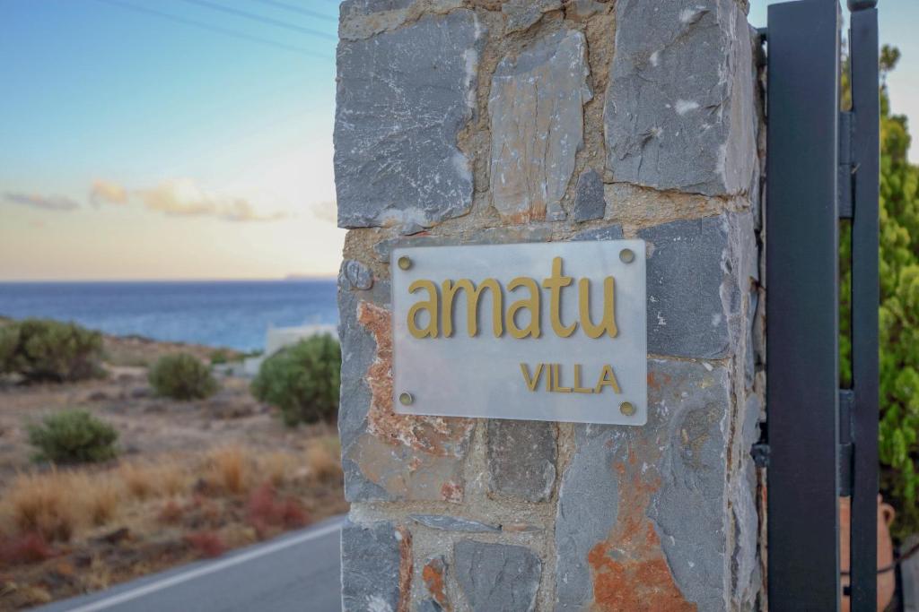 un panneau sur le côté d'un mur de pierre dans l'établissement Amatu Villa (Jupiter), à Xerokampos