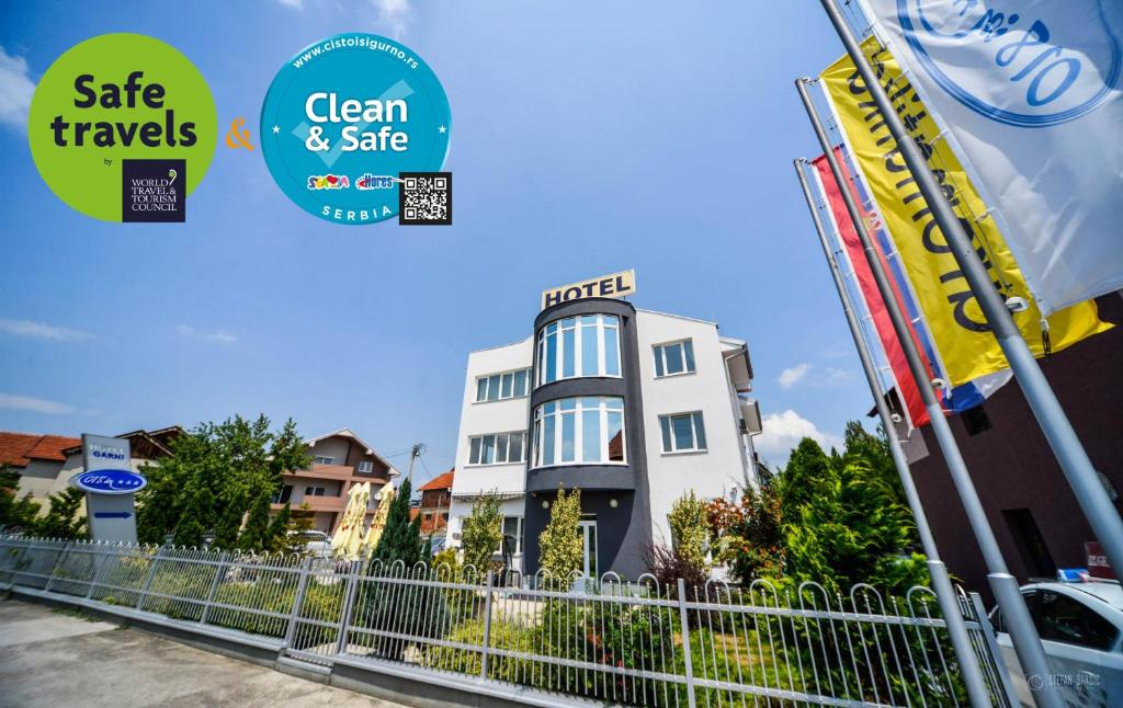 a building with a fence in front of it at Garni Hotel 018 In in Niš