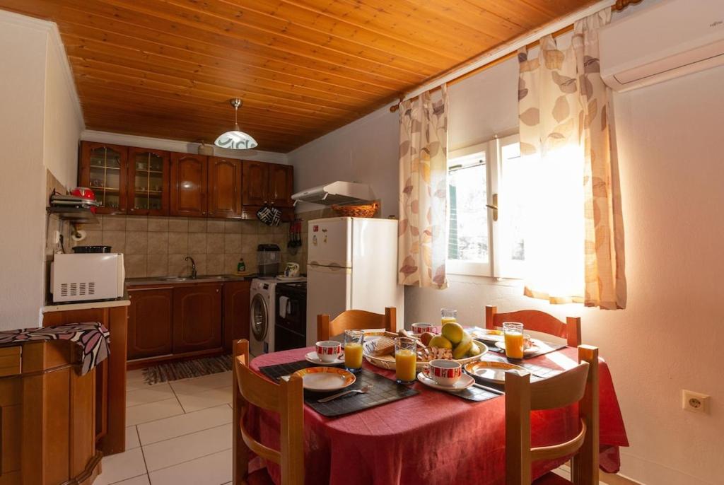 a kitchen with a table with a red table cloth at Serenity House in Ágios Matthaíos