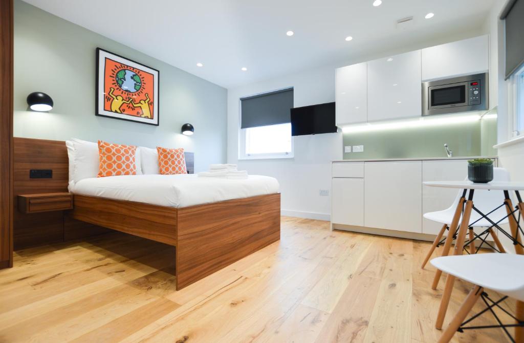 a small bedroom with a bed and a kitchen at Shepherds Bush Green Serviced Apartments by Concept Apartments in London