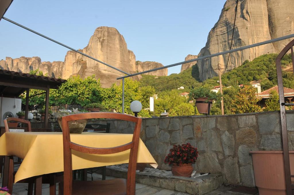 een gele tafel en stoel met een berg op de achtergrond bij GUESTHOUSE BLOUTSOS ROOMS in Kastraki