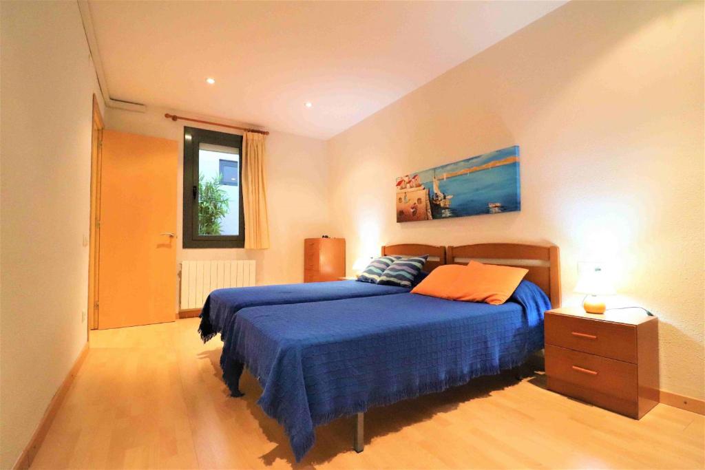 a bedroom with a blue bed and a window at Tramuntana 2 1 Roses- Immo Barneda in Roses