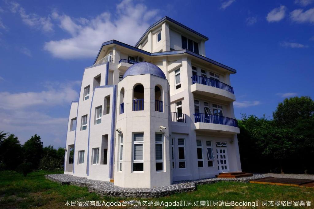 Un bâtiment blanc avec un dôme en haut dans l'établissement 梅花湖 轉角民宿, à Dongshan