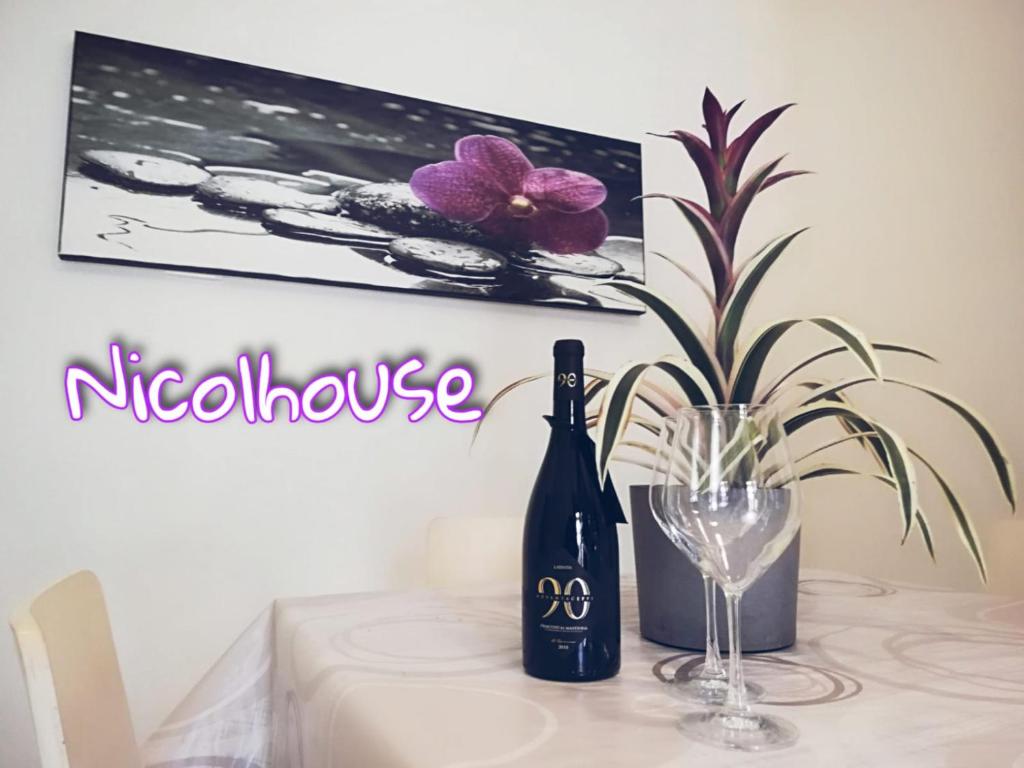 einen Tisch mit einer Flasche Wein und einer Blume in der Unterkunft Nicolhouse in Bari
