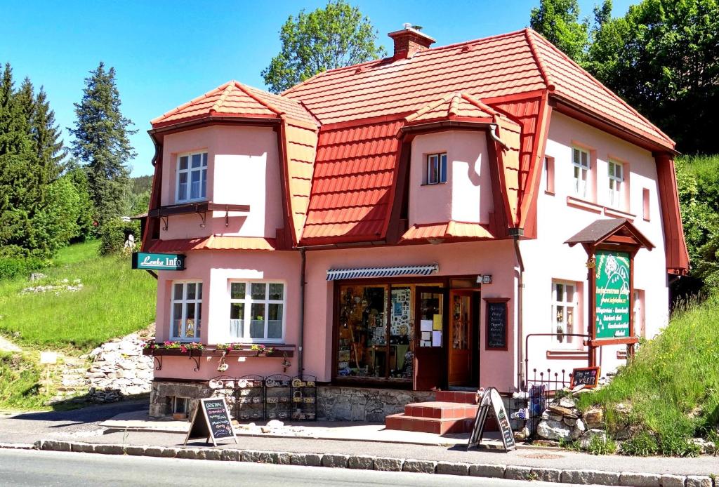 ein Haus mit rotem Dach an der Straßenseite in der Unterkunft Vila Lenka in Rokytnice nad Jizerou