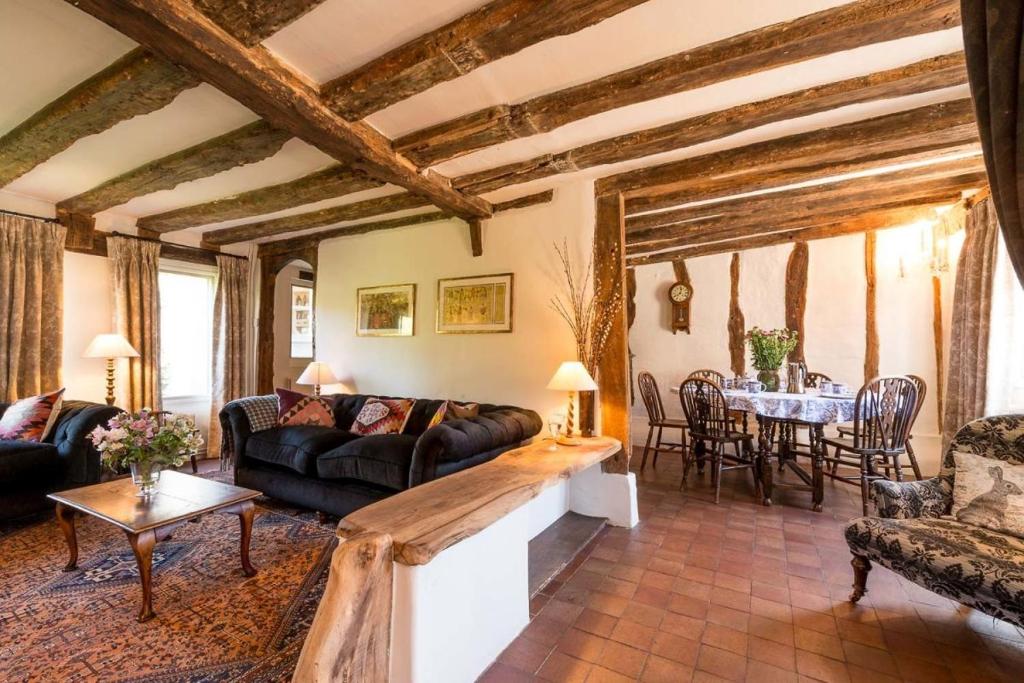 a living room with a couch and a table at Water Cottage, a perfect ancient House in Suffolks prettiest tiny village in Kersey