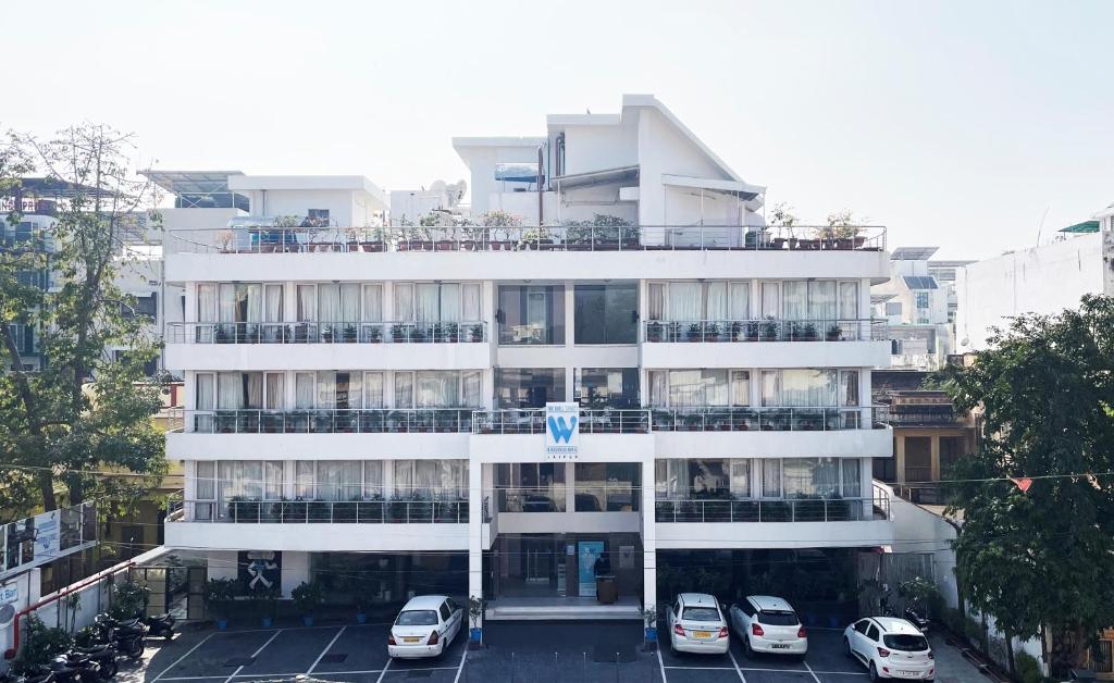 a white building with cars parked in a parking lot at The Wall Street Beacon, Jaipur in Jaipur