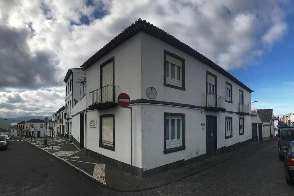 un bâtiment blanc sur le côté d'une rue dans l'établissement Costa Norte Guesthouse, à Ribeira Grande