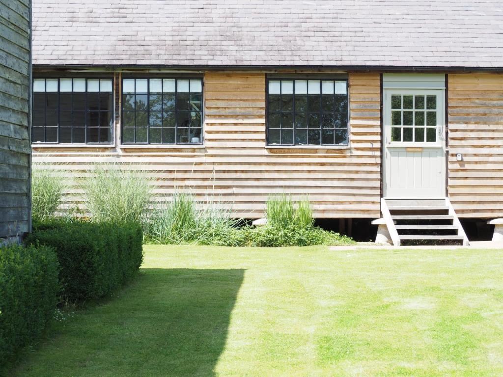 a house with a white door and a grass yard at The Fisherman's Lodge in Andover