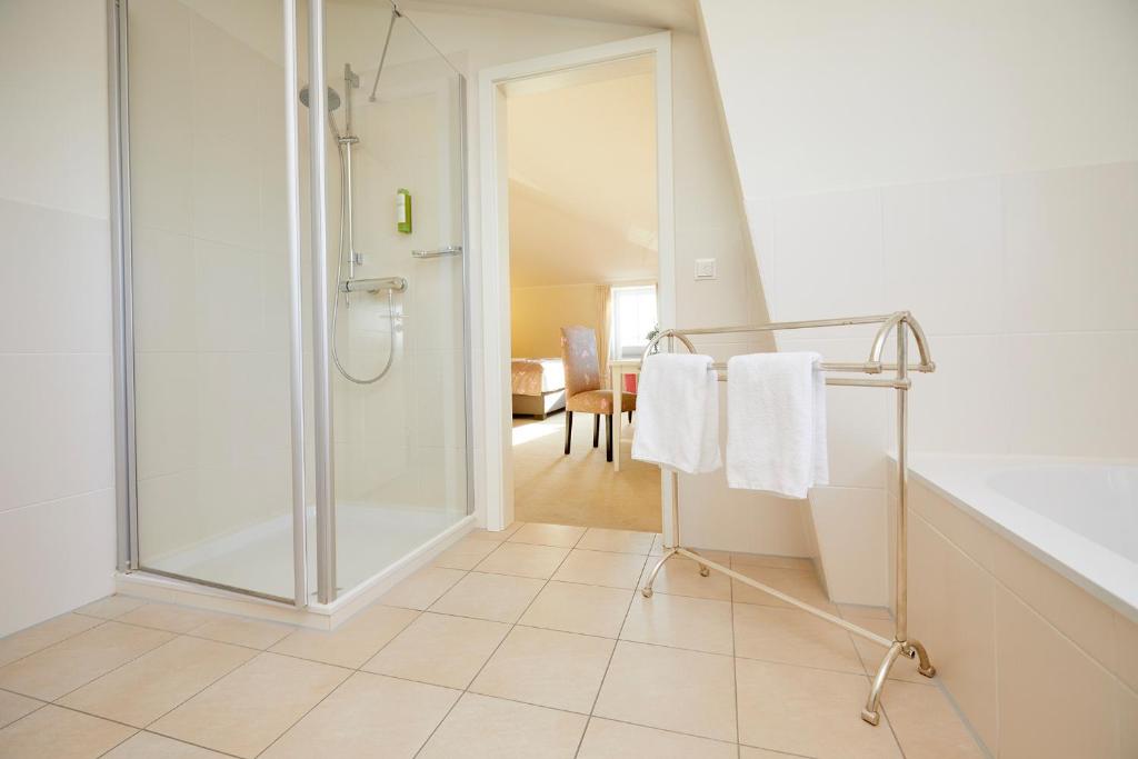 a bathroom with a shower and white towels at Kino-Hotel Meyer in Harsefeld
