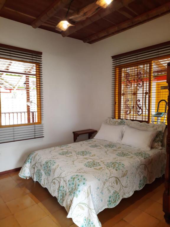 a bedroom with a bed and two windows at FINCA HOTEL DON JULIO in Santa Rosa de Cabal