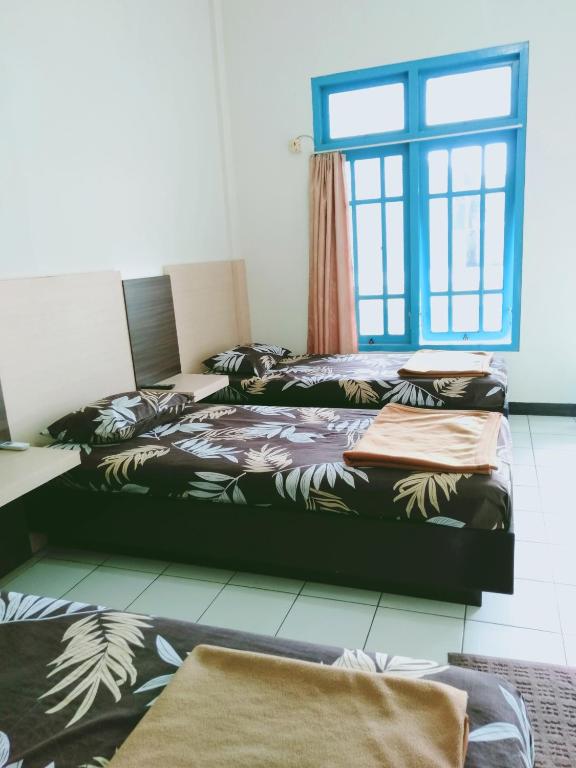 Postel nebo postele na pokoji v ubytování Hotel Taman Indah