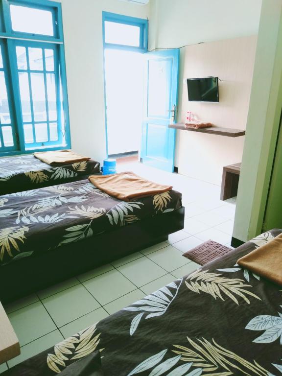 Postel nebo postele na pokoji v ubytování Hotel Taman Indah