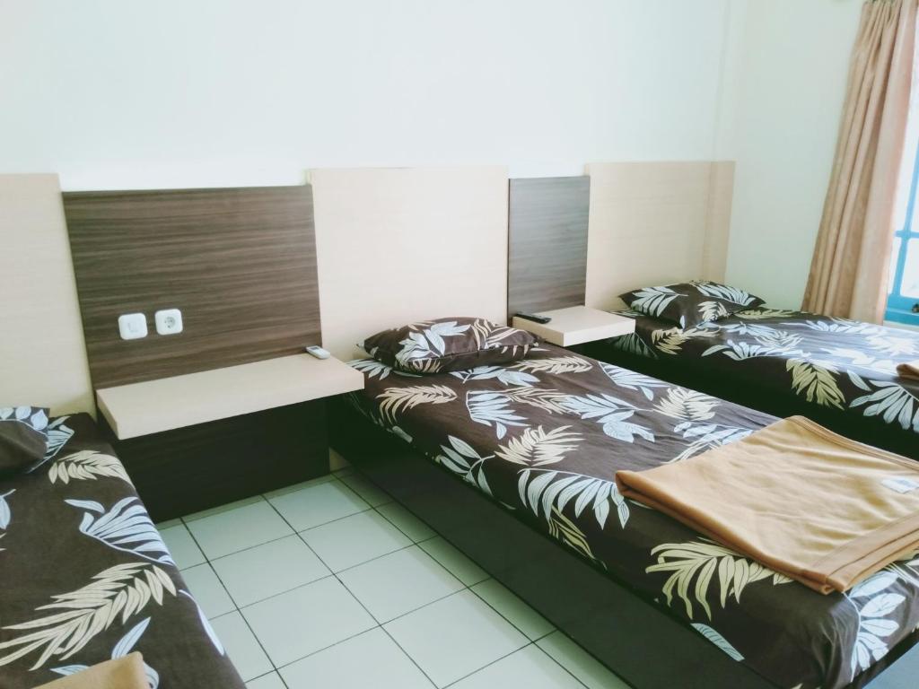 Postel nebo postele na pokoji v ubytování Hotel Taman Indah