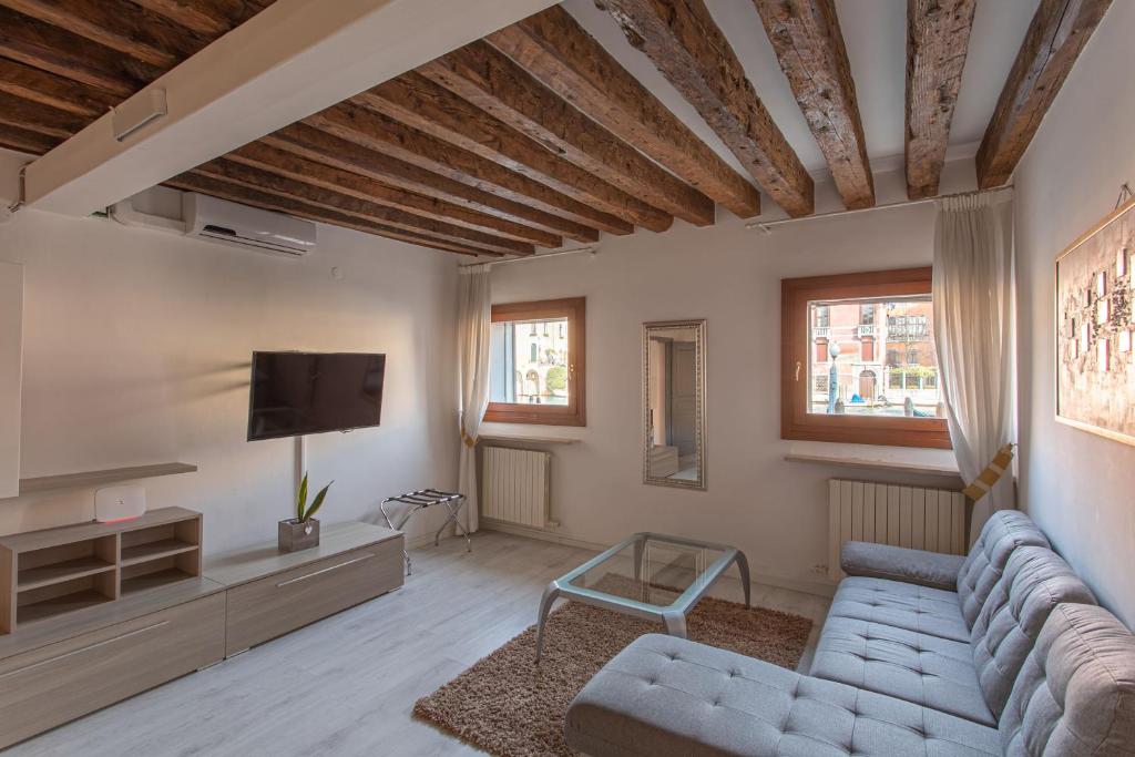 un soggiorno con divano e TV di Canaletto Apartment Rialto a Venezia