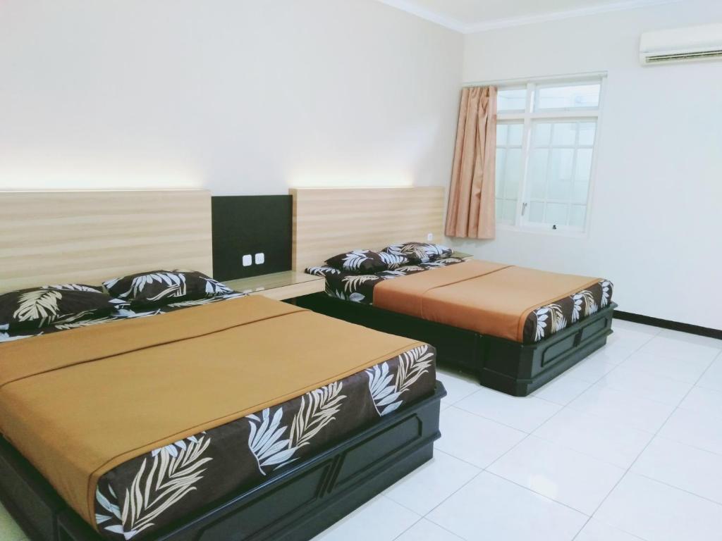 Postel nebo postele na pokoji v ubytování Hotel Taman Indah