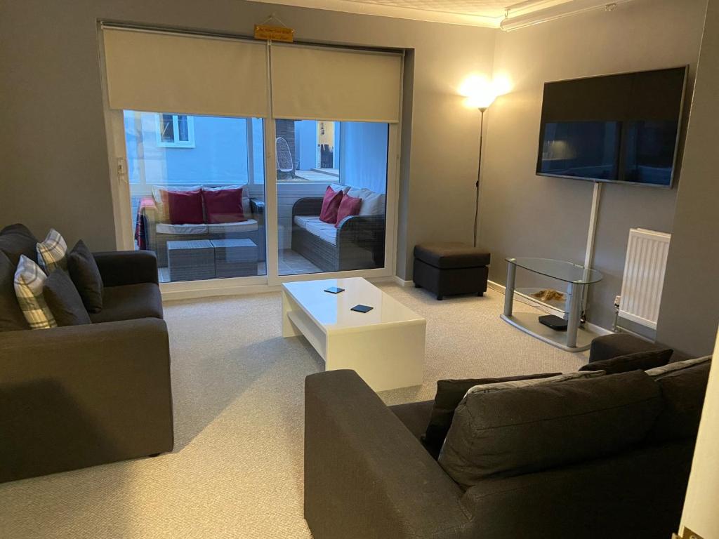 uma sala de estar com um sofá, uma mesa e uma televisão em Palmbeach Place em Kent