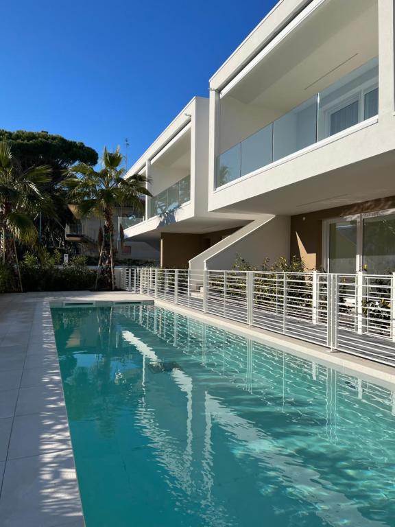 a swimming pool in front of a house at Agua Apartment with beach included in Lido di Jesolo