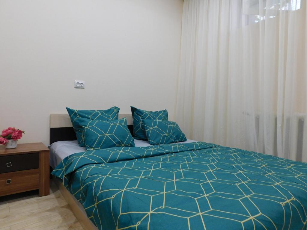 a bedroom with a bed with a blue comforter at Апартамент в курзоне пр Кирова 7 in Pyatigorsk