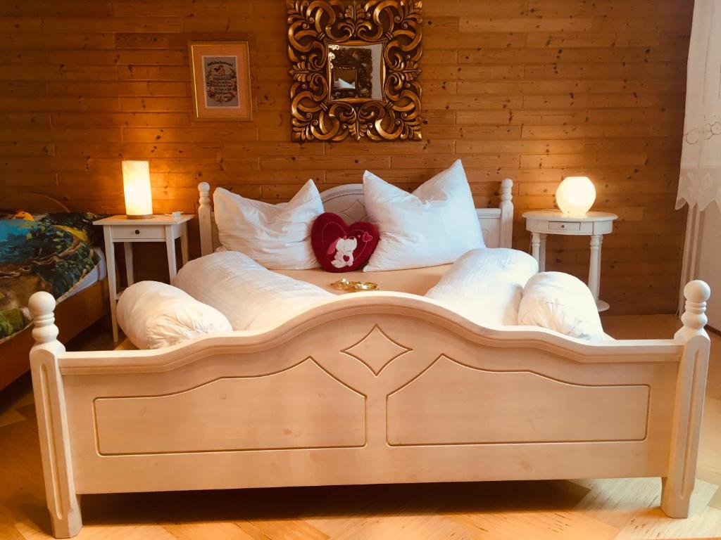 duże łóżko z białymi poduszkami i różowym łukiem w obiekcie Familienapartment mit Balkon und Garten w mieście Ober-Lembach
