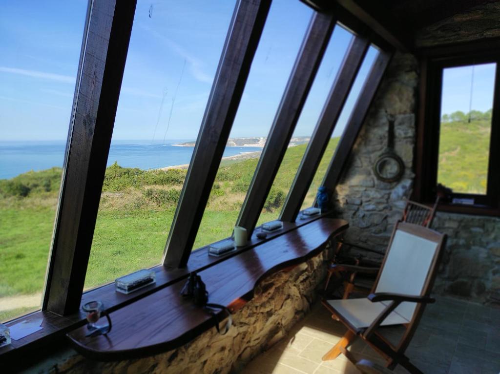 a room with windows with a view of the ocean at Pines of Salgado beachview villa by Book YourHoliday PT in Nazaré