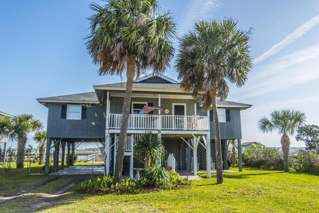 a house with palm trees in front of it at Escape in Edisto Island